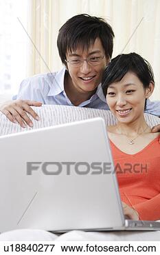 Picture - young couple looking 
at laptop. fotosearch 
- search stock 
photos, pictures, 
images, and photo 
clipart