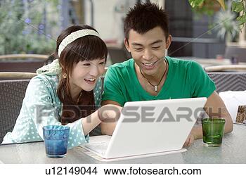 Stock Photo - young lovers playing 
with laptop near 
two glass of drink. 
fotosearch - search 
stock photos, 
pictures, images, 
and photo clipart