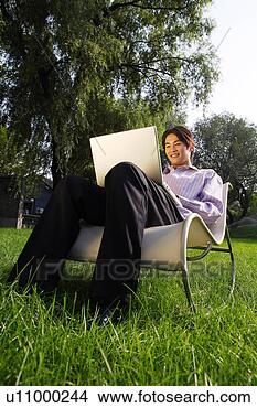 Stock Photo - young man on a 
chair with laptop 
on lawn. fotosearch 
- search stock 
photos, pictures, 
images, and photo 
clipart
