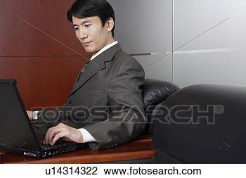 Stock Photo - young man playing 
laptop in sofa. 
fotosearch - search 
stock photos, 
pictures, images, 
and photo clipart