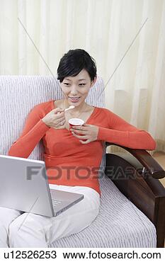 Stock Photo - young woman looking 
at laptop. fotosearch 
- search stock 
photos, pictures, 
images, and photo 
clipart