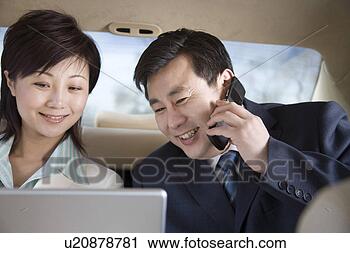 Stock Photography - young woman looking 
at laptop,  talking 
on cellphone, 
 sitting with. 
fotosearch - search 
stock photos, 
pictures, images, 
and photo clipart