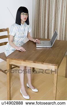 Stock Photo - young woman playing 
with laptop at 
desk. fotosearch 
- search stock 
photos, pictures, 
images, and photo 
clipart