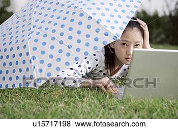Stock Photo - young woman playing 
laptop under umbrella. 
fotosearch - search 
stock photos, 
pictures, images, 
and photo clipart
