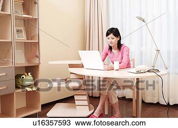 Stock Photo - young woman playing 
with laptop at 
desk. fotosearch 
- search stock 
photos, pictures, 
images, and photo 
clipart