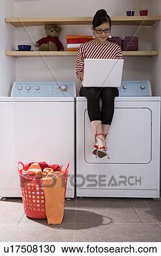 Stock Photography - young woman playing 
with laptop on 
washer. fotosearch 
- search stock 
photos, pictures, 
images, and photo 
clipart