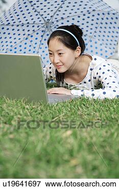 Picture - young woman playing 
laptop under umbrella. 
fotosearch - search 
stock photos, 
pictures, images, 
and photo clipart