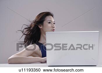 Stock Photography - young woman sitting 
at desk with laptop. 
fotosearch - search 
stock photos, 
pictures, images, 
and photo clipart