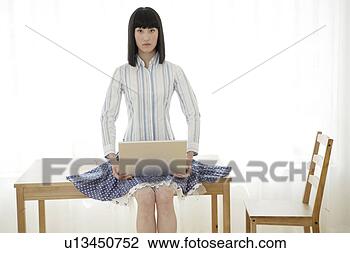 Stock Photo - young woman sitting, 
holding a laptop. 
fotosearch - search 
stock photos, 
pictures, images, 
and photo clipart