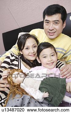 Stock Photography - family and doll 
into camera. fotosearch 
- search stock 
photos, pictures, 
images, and photo 
clipart