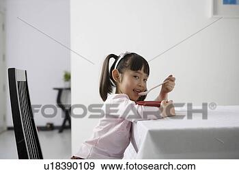 Stock Photograph - girl eating at 
the dinning table. 
fotosearch - search 
stock photos, 
pictures, images, 
and photo clipart