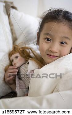 Picture - girl holding a 
doll in bedclothes. 
fotosearch - search 
stock photos, 
pictures, images, 
and photo clipart