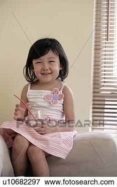Picture - girl holding a 
glass of milk 
in sofa. fotosearch 
- search stock 
photos, pictures, 
images, and photo 
clipart