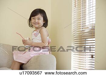 Picture - girl holding a 
glass of milk 
in sofa. fotosearch 
- search stock 
photos, pictures, 
images, and photo 
clipart