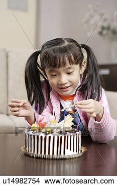 Stock Photo - girl lighting 
candles on cake. 
fotosearch - search 
stock photos, 
pictures, images, 
and photo clipart