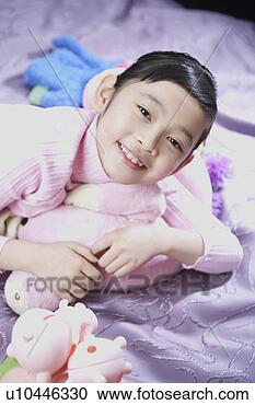 Stock Photography - girl playing with 
dolls in bed. 
fotosearch - search 
stock photos, 
pictures, images, 
and photo clipart