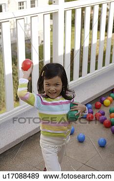 Stock Photograph - girl playing toy 
balls in front 
of an enclosure. 
fotosearch - search 
stock photos, 
pictures, images, 
and photo clipart