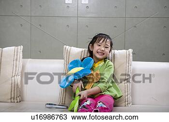 Stock Photo - girl sitting, 
holding a doll. 
fotosearch - search 
stock photos, 
pictures, images, 
and photo clipart