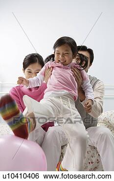 Stock Photo - young family in 
bed, daughter 
playing with a 
balloon. fotosearch 
- search stock 
photos, pictures, 
images, and photo 
clipart