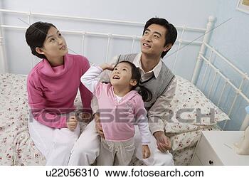 Stock Photography - young family sitting 
in bed. fotosearch 
- search stock 
photos, pictures, 
images, and photo 
clipart