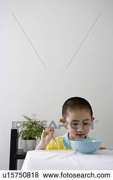Stock Photo - boy holding chopsticks, 
looking at blue 
bowl. fotosearch 
- search stock 
photos, pictures, 
images, and photo 
clipart