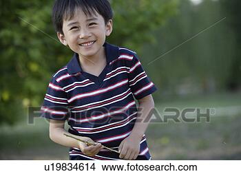 Stock Photo - boy holding a 
rod, smiling. 
fotosearch - search 
stock photos, 
pictures, images, 
and photo clipart