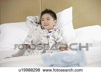 Stock Photo - boy lying in bed. 
fotosearch - search 
stock photos, 
pictures, images, 
and photo clipart