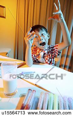 Stock Photo - boy making face 
at desk. fotosearch 
- search stock 
photos, pictures, 
images, and photo 
clipart