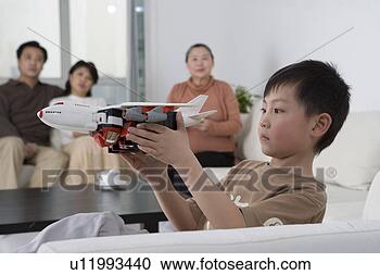 Stock Photography - boy playing with 
airplane model 
in sofa. fotosearch 
- search stock 
photos, pictures, 
images, and photo 
clipart