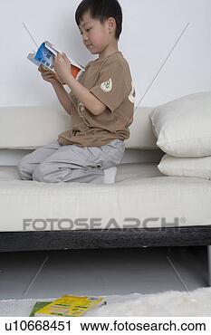 Stock Photography - boy reading book 
in sofa. fotosearch 
- search stock 
photos, pictures, 
images, and photo 
clipart