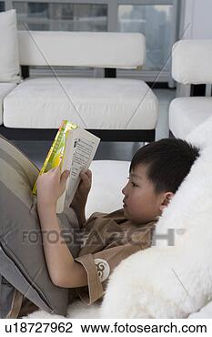 Stock Photo - boy reading book 
in sofa. fotosearch 
- search stock 
photos, pictures, 
images, and photo 
clipart