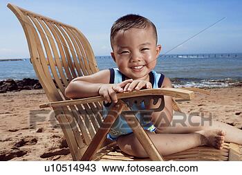 Stock Photo - boy sitting on 
wooden chair on 
beach. fotosearch 
- search stock 
photos, pictures, 
images, and photo 
clipart