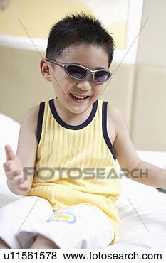 Stock Photo - boy wearing a 
sunglass, playing 
in bed. fotosearch 
- search stock 
photos, pictures, 
images, and photo 
clipart