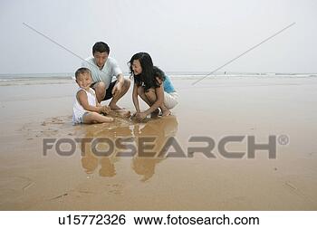 Stock Photo - family members 
playing sand on 
beach. fotosearch 
- search stock 
photos, pictures, 
images, and photo 
clipart