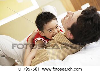 Stock Photography - young father and 
son playing in 
bed. fotosearch 
- search stock 
photos, pictures, 
images, and photo 
clipart