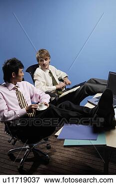 Picture - occidental young 
man and asian 
young man sitting 
on chair with 
legs. fotosearch 
- search stock 
photos, pictures, 
images, and photo 
clipart