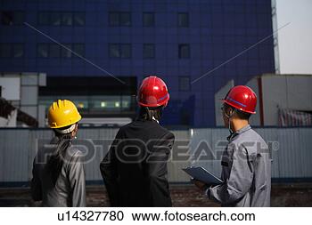 Stock Photography - people in safety 
helmets looking 
at a building. 
fotosearch - search 
stock photos, 
pictures, images, 
and photo clipart