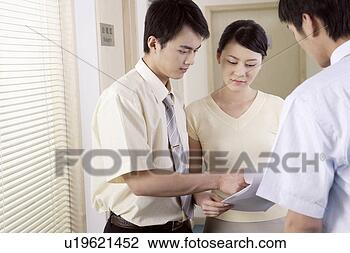 Stock Photo - two young men 
and young woman 
discussing over 
files at corridor. 
fotosearch - search 
stock photos, 
pictures, images, 
and photo clipart