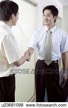 Stock Photo - two young men 
shaking hand at 
corridor. fotosearch 
- search stock 
photos, pictures, 
images, and photo 
clipart