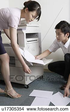 Stock Photo - young man picking 
paper up to young 
woman near copy 
machine. fotosearch 
- search stock 
photos, pictures, 
images, and photo 
clipart