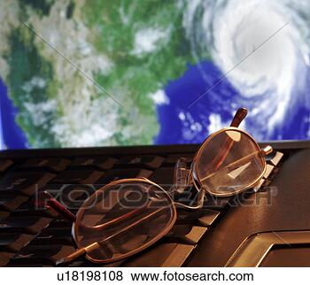 Stock Photo - tracking a hurricane 
portrayed by eyeglasses 
atop a laptop 
computer. fotosearch 
- search stock 
photos, pictures, 
images, and photo 
clipart
