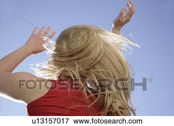 Picture - young woman throwing 
her long blond 
hair in front 
of blue sky,  
low. fotosearch 
- search stock 
photos, pictures, 
images, and photo 
clipart