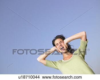 Stock Photo - woman covering 
ears and screaming 
outdoors. fotosearch 
- search stock 
photos, pictures, 
images, and photo 
clipart