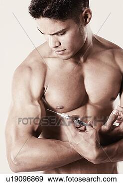 Stock Photograph - close-up of a 
young man holding 
a syringe against 
his biceps. fotosearch 
- search stock 
photos, pictures, 
images, and photo 
clipart
