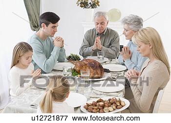 Picture - family saying  grace at thanksgiving  table. fotosearch  - search stock  photos, pictures,  wall murals, images,  and photo clipart