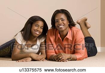 Stock Image - mother and daughter 
laying on the 
floor smiling 
and posing. fotosearch 
- search stock 
photos, pictures, 
images, and photo 
clipart
