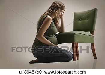 Stock Photography - a sad pregnant 
woman sitting 
by chair. fotosearch 
- search stock 
photos, pictures, 
images, and photo 
clipart