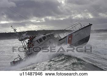 Stock Photo - us coast guard 
motor life boat 
(47268) brakes 
a wave during 
a rescue. fotosearch 
- search stock 
photos, pictures, 
images, and photo 
clipart
