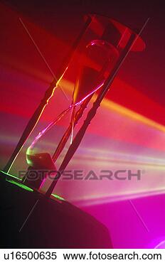 Stock Image - an hourglass illuminated 
by multi-colored 
laser lights shining 
through. fotosearch 
- search stock 
photos, pictures, 
images, and photo 
clipart