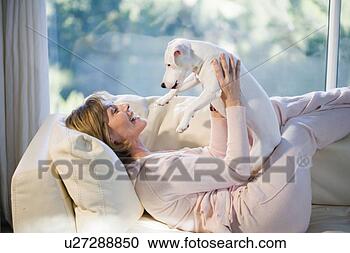 Stock Photography - woman relaxing, 
playing with dog. 
fotosearch - search 
stock photos, 
pictures, images, 
and photo clipart